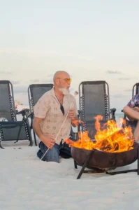 man and woman at the beach bonfire