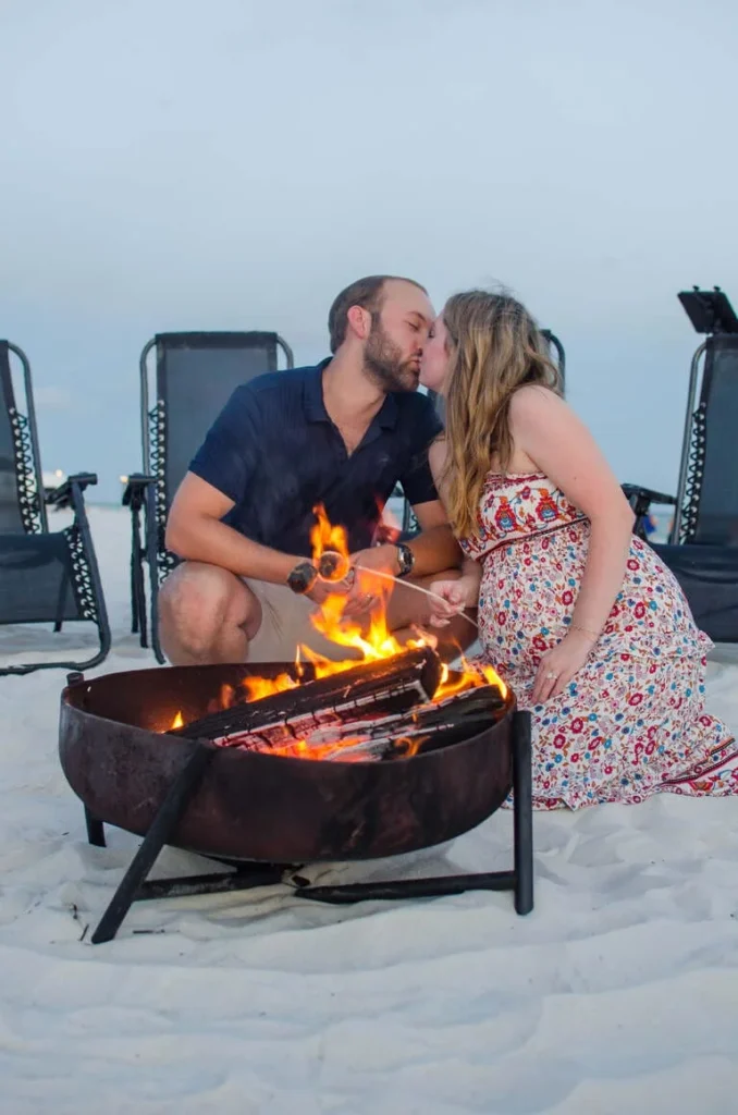 a wedding photography of couple kissing under a bonfire
