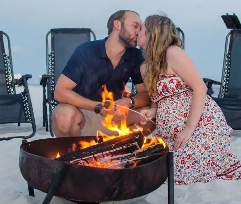 a wedding photography of couple kissing under a bonfire