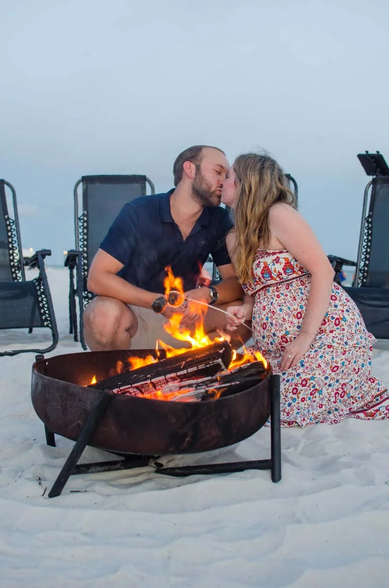 a wedding photography of couple kissing under a bonfire